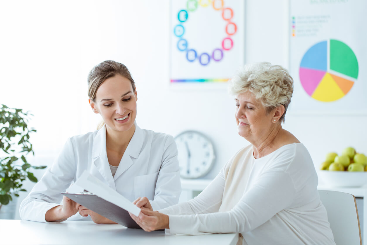 Smiling nutritionist showing personalised weight-loss diet plan to the patient